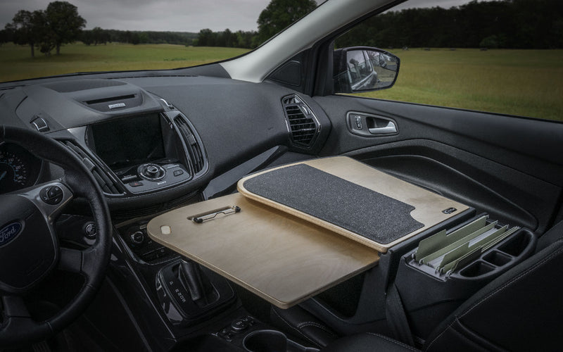 An AutoExec GripMaster Car Desk with Slim-Grip® Ultra Pro Drill-Base Mount from Arkon Mounts is installed over the passenger seat in a car, transforming it into a functional mobile workstation and creating an efficient office space on the go.