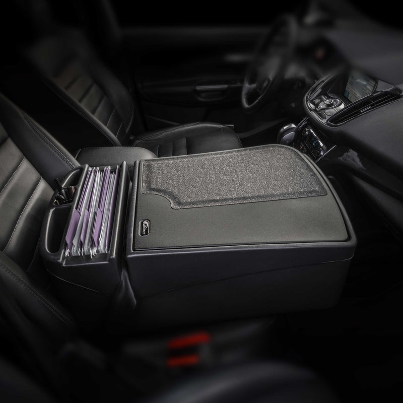 A car’s front seat interior showcases the Arkon Mounts AutoExec GripMaster Car Desk on the passenger seat, serving as a mobile workstation. This setup allows files or folders to be neatly arranged in an upright divider, topped with a gray, textured cover for organization and convenience.
