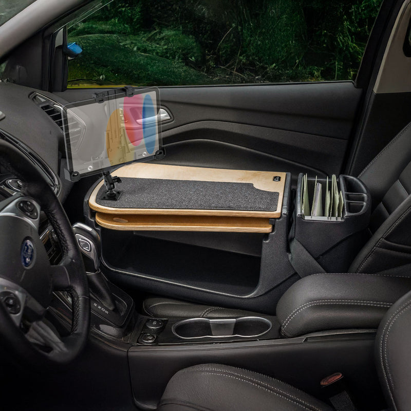The AutoExec GripMaster Car Desk with LockVise™ Locking Tablet Holder and Multi-Angle Mount is installed over the front passenger seat, transforming the vehicle interior into a convenient mobile workstation.