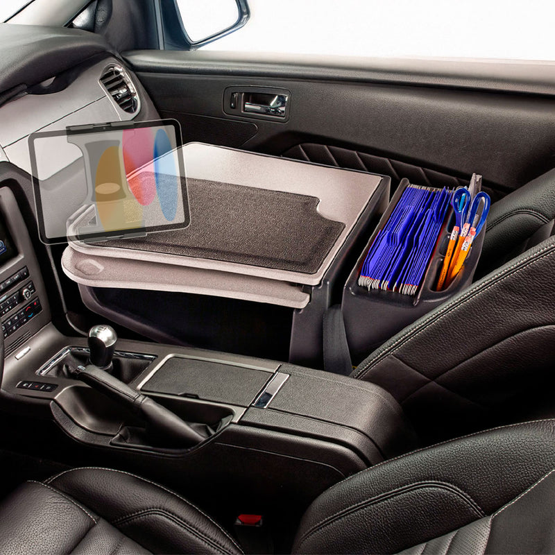 A car’s passenger seat holds an Arkon Mounts AutoExec GripMaster Car Desk with Slim-Grip® Ultra Pro Drill-Base Mount, featuring a document organizer, pens, and folders to transform the vehicle into a mobile workstation. The dashboard and gear shift appear in the foreground.