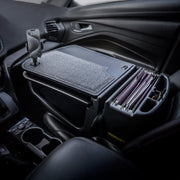 The AutoExec GripMaster Car Desk with Mega Grip™ Drill-Base Mount, featuring a felt surface and integrated file organizer, is installed in the passenger seat of a car to transform it into an organized mobile office for working on the go.