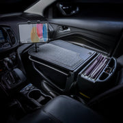A car interior equipped with the AutoExec GripMaster Car Desk, featuring a felt-covered writing surface, the LockVise™ locking tablet holder with multi-angle mount, and organized files conveniently arranged next to the driver’s seat.