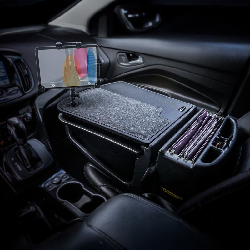 A car interior equipped with the AutoExec GripMaster Car Desk, featuring a felt-covered writing surface, the LockVise™ locking tablet holder with multi-angle mount, and organized files conveniently arranged next to the driver’s seat.