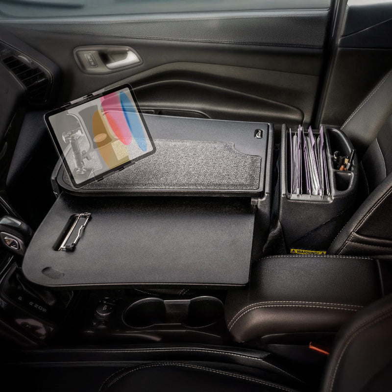 A car interior featuring the AutoExec GripMaster Car Desk with Slim-Grip® Ultra Pro Multi-Angle Mount by Arkon Mounts, equipped with a built-in tablet holder, clipboard, folders, and office supplies—perfectly illustrating a fully functional mobile office set up in the front passenger seat.