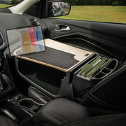 A GripMaster Efficiency Car Desk with Slim-Grip® Ultra Pro Drill-Base Mount by Arkon Mounts is set up in the front passenger seat, featuring a wooden desk surface, a cushioned mat, organized file folders, and a tablet securely held in its dedicated holder—transforming the car into a convenient mobile office workspace.