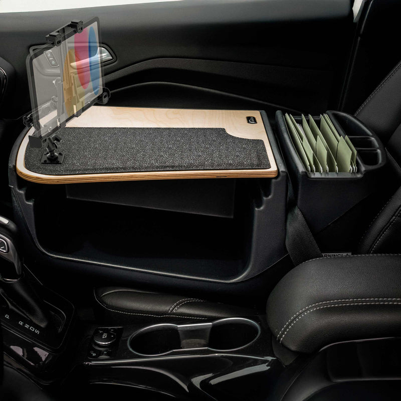 A car interior features the AutoExec GripMaster Efficiency Car Desk, equipped with a LockVise® Locking Tablet Holder and multi-angle mount, a felt-covered work surface, and organized file folders beside the passenger seat. This mobile workstation fits securely in the passenger footwell.