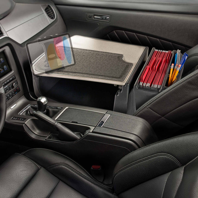 The front seat of a car features the GripMaster Efficiency Car Desk with Slim-Grip® Ultra Pro Drill-Base Mount by Arkon Mounts, equipped with a tablet holder, file organizer containing red folders, and pens—creating a mobile office workspace that installs securely with the convenient drill base mount.