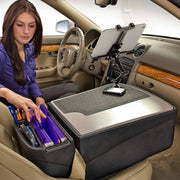 A woman in a car organizes files on the AutoExec GripMaster Efficiency Car Desk, which serves as her mobile workstation on the passenger seat. A tablet and phone are mounted securely with the LockVise® Locking Tablet Holder and Multi-Angle Mount, and the car features tan seats with wood paneling on the door.