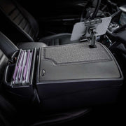 Here’s a revised version of the sentence using your provided product data: A car’s front seat equipped with the Arkon Mounts GripMaster Efficiency Car Desk, featuring a Slim-Grip® Ultra Pro Drill-Base Mount, holds hanging file folders and includes a mounted tablet holder, creating an organized workspace for managing documents and digital devices while parked.