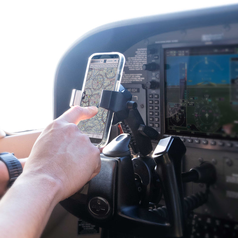 A pilot uses the SkyHold™ Yoke Phone Mount in the cockpit to display a digital navigation map, with aircraft instruments and screens visible in the background.