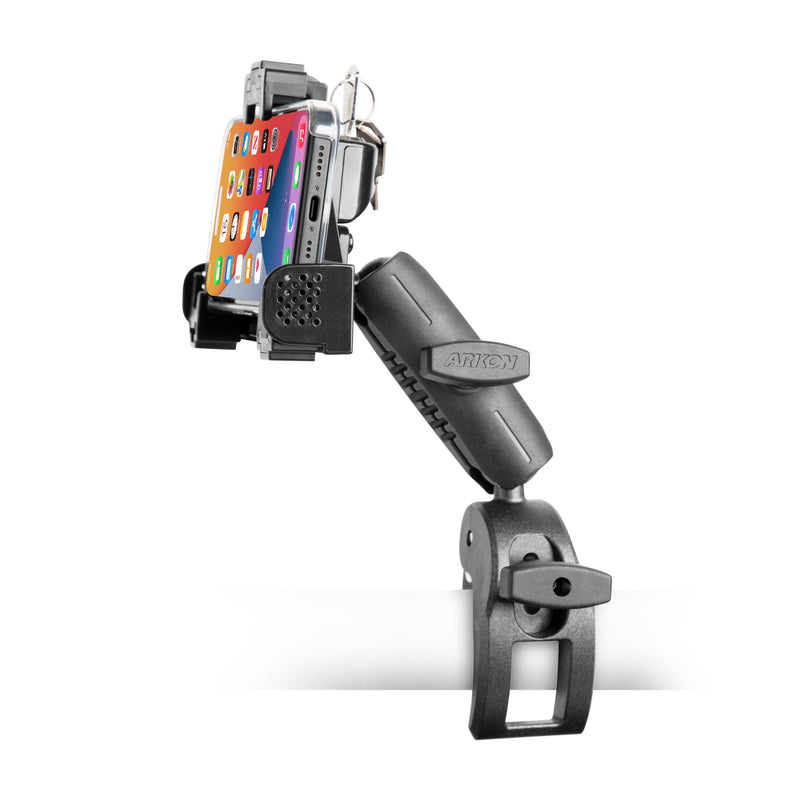The SkyHold™ Yoke Locking Phone Mount, in black, attaches to the edge of a white surface and securely holds a smartphone displaying colorful app icons.