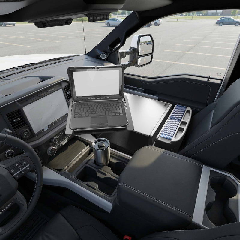 An Arkon Mounts AutoExec Reach Front Seat Car Desk sits open in the passenger seat of a modern vehicle, holding a rugged laptop and a travel mug in the cupholder, while an empty parking lot is visible through the window—creating an efficient mobile workspace for productivity on the go.