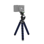 The 11 Inch Flexible Camera Tripod for Canon, Nikon, Samsung, and other 1/4-20 digital cameras with black and blue striped legs holds a compact camera on a white background—ideal for content creators.