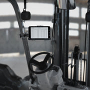 A LockVise™ Metal Locking Front Guard Tablet Mount with 8.5″ Metal Robust™ Shaft is installed inside a forklift cabin, securely holding a tablet that displays a spreadsheet on its screen, with the forklift’s controls and mechanical parts visible in the background.