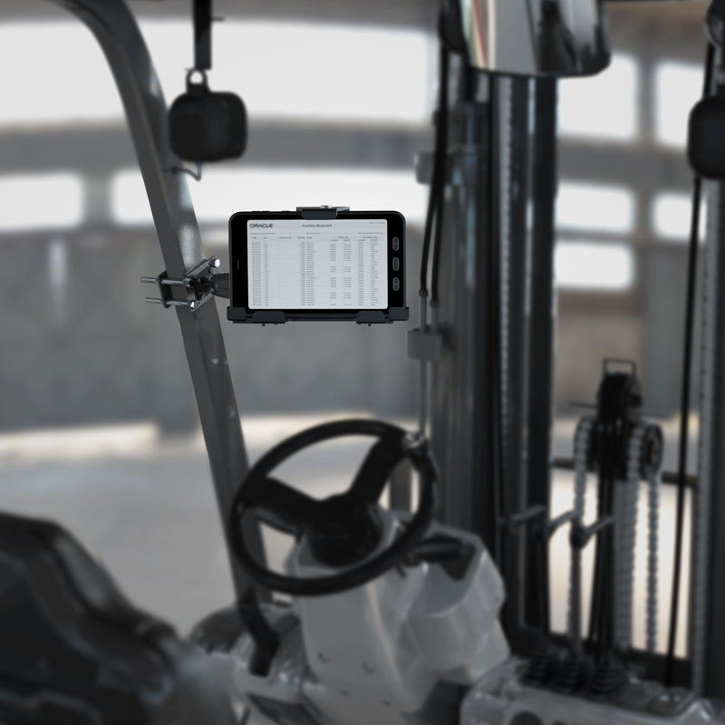 A LockVise™ Metal Locking Front Guard Tablet Mount with 8.5″ Metal Robust™ Shaft is installed inside a forklift cabin, securely holding a tablet that displays a spreadsheet on its screen, with the forklift’s controls and mechanical parts visible in the background.