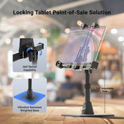 The LockVise™ POS Locking Tablet Stand is displayed on a wooden table, featuring a secure locking tablet holder, 360° swivel functionality, a weighted vibration-resistant base, and a 7.5-inch adjustable pole—all set against a blurred café background.