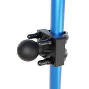 An Arkon Mounts U-Bolt Round Bar Mount with a 38mm metal ball is clamped onto a blue cylindrical pole using four bolts with rounded caps, forming part of a modular mounting solution.