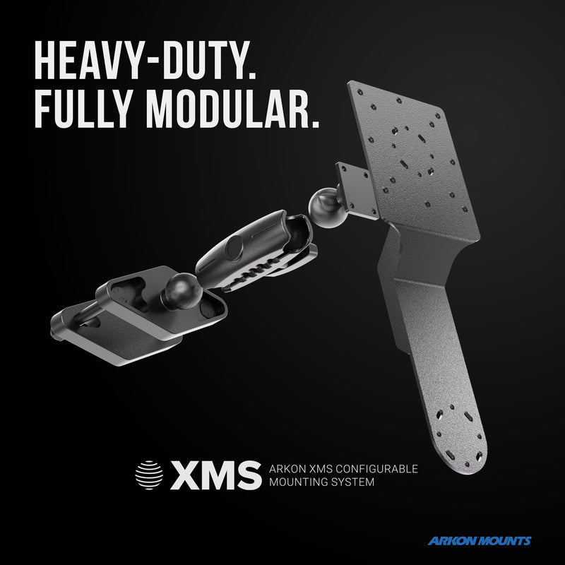 A rugged, fully modular mounting solution with adjustable components for versatile warehouse device installation, shown on a black background. Text reads: HEAVY-DUTY. FULLY MODULAR. XMS™ Heavy Duty Forklift Mount with Dual Utility Mounting Bracket—VESA and AMPS compatible for flexible configuration options. Arkon Mounts logo at the bottom.