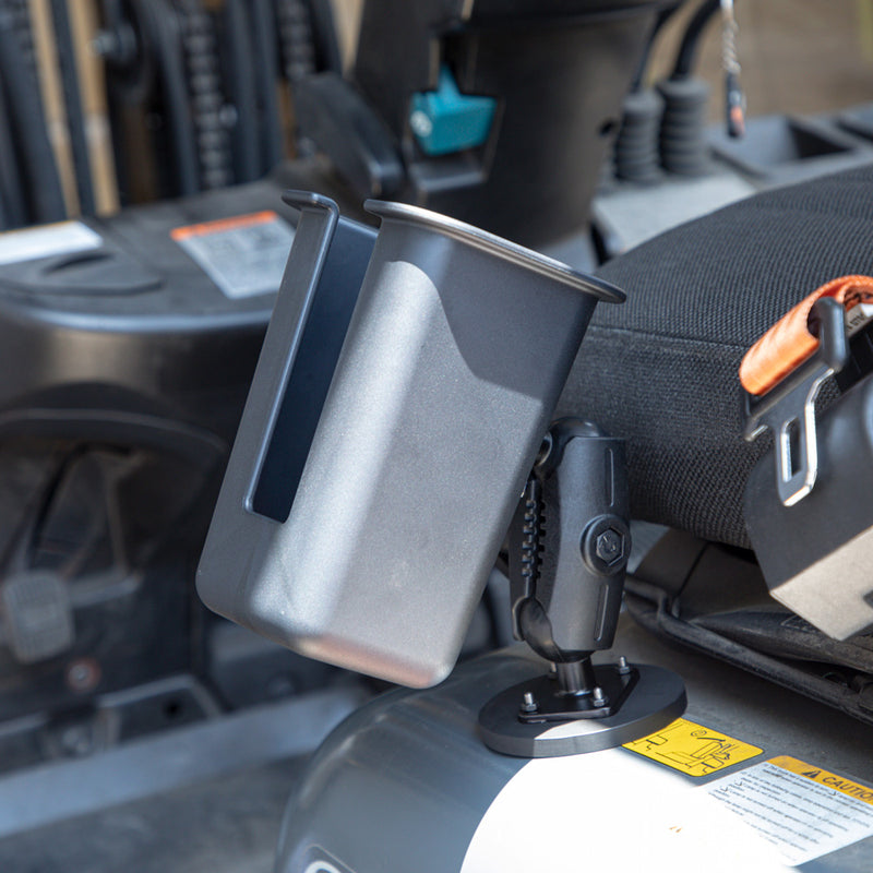 An Arkon Mounts Magnetic Mount Device & Barcode Scanner Holder, made of gray plastic and designed for industrial use, is securely attached to a metal base beside a vehicle seat—likely in a forklift—with the seatbelt and control panel visible in the background.