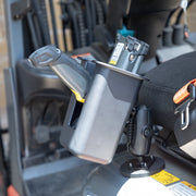 A close-up of an Arkon Mounts Magnetic Mount Device & Barcode Scanner Holder, with a barcode scanner resting securely in its charging cradle on the mount next to the seat inside a vehicle or heavy equipment cabin.