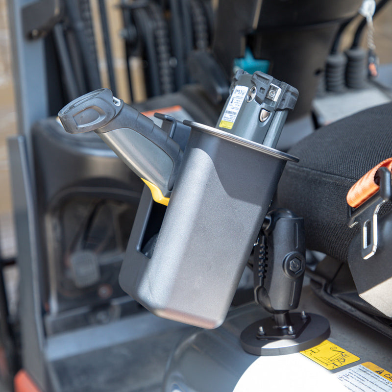 A close-up of an Arkon Mounts Magnetic Mount Device & Barcode Scanner Holder, with a barcode scanner resting securely in its charging cradle on the mount next to the seat inside a vehicle or heavy equipment cabin.
