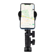 A smartphone is mounted vertically on the black RoadVise® Ratchet Phone Holder with Drill Base Mount, displaying a map app. The universally compatible holder with a secure drill base is attached to a flat surface.