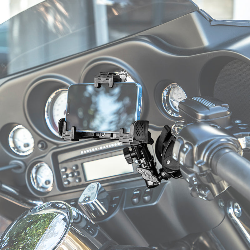 The LockVise™ Universal Locking Phone Holder with Multi-Angle and Clamp Mount securely attaches your smartphone to your motorcycle handlebar, with the dashboard, gauges, and windshield visible in the background.