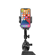 A smartphone is secured in the Mega Grip™ Phone Holder with Multi-Angle Arm and Clamp Mount, showing its home screen with app icons against a white background.