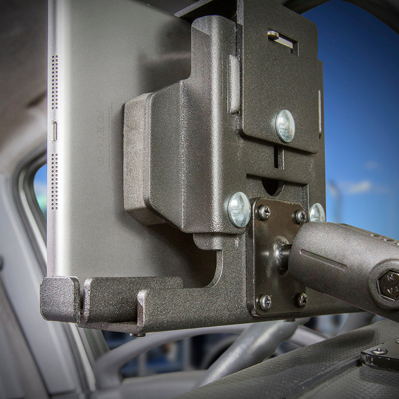 Close-up of the LockVise™ Metal Locking Tablet Mount Bundle with USB and Quick Hardwire Adapter securely holding a tablet next to the driver’s seat inside a vehicle, with parts of the car interior and a window visible in the background.