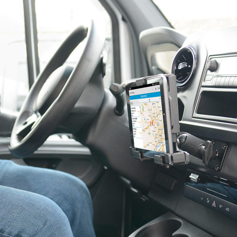 A person sits in a car with a tablet securely held by the LockVise™ Metal Locking Tablet Mount with Drill Base Mount near the dashboard, displaying a map and navigation route.