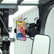 A RoadVise® XL Phone and Midsize Tablet Magnetic Mount secures a smartphone with a heavy-duty magnetic base to the vehicles frame near the rear-view mirror, displaying its home screen apps.