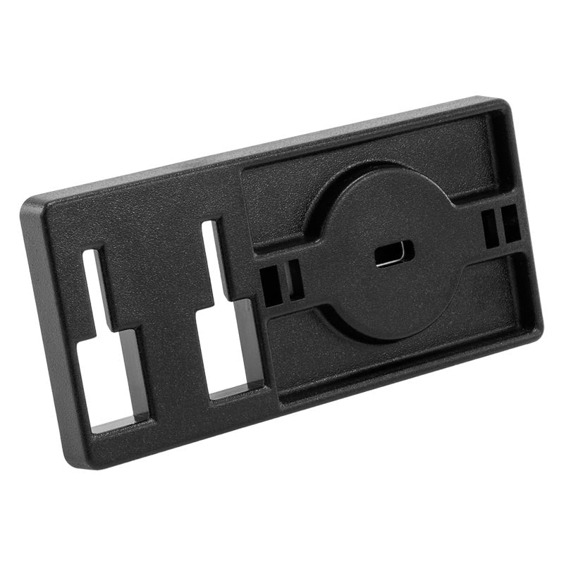 The Adhesive Security Plate features a black rectangular bracket with dual left T-slots and a right circular slot, designed for use with security cables or mounting to secure compatible components.
