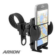 A black Bike or Motorcycle Mega Grip™ Phone Holder Strap Mount is attached to a handlebar, securely holding a Samsung phone with a map. The Arkon logo in the lower left highlights this universal mount for iPhone, Galaxy, and Note in action.