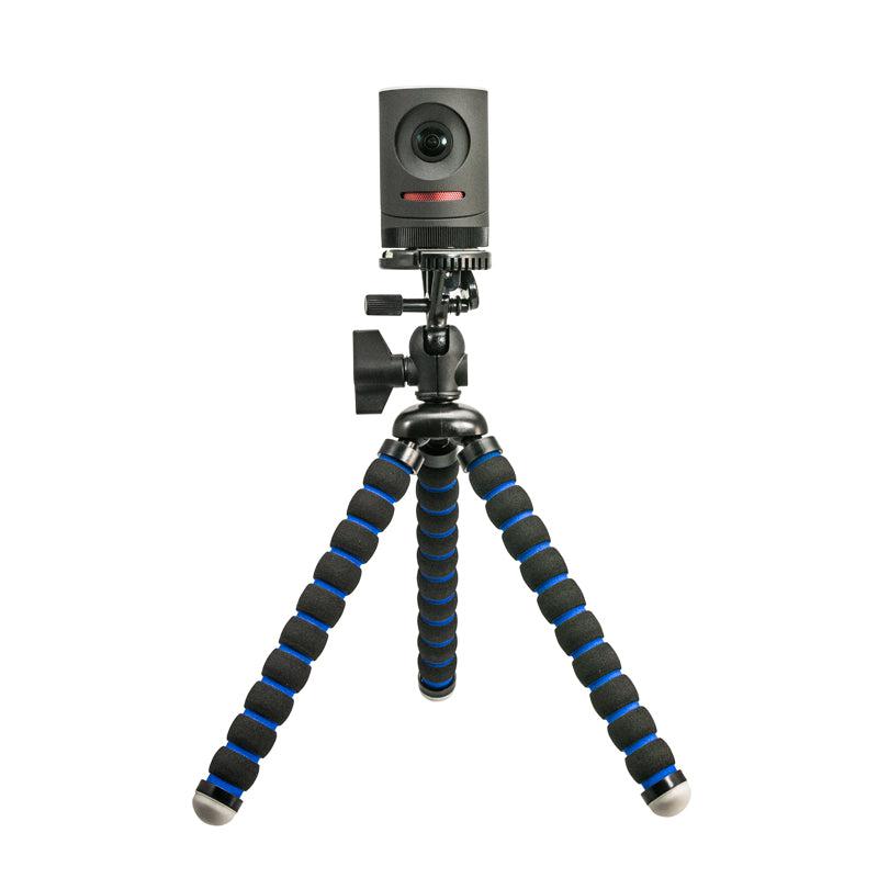 A Mevo live streaming camera is mounted on the Camera Tripod Mount for Mevo, featuring three flexible legs with black and blue foam grips, standing upright on a white background.