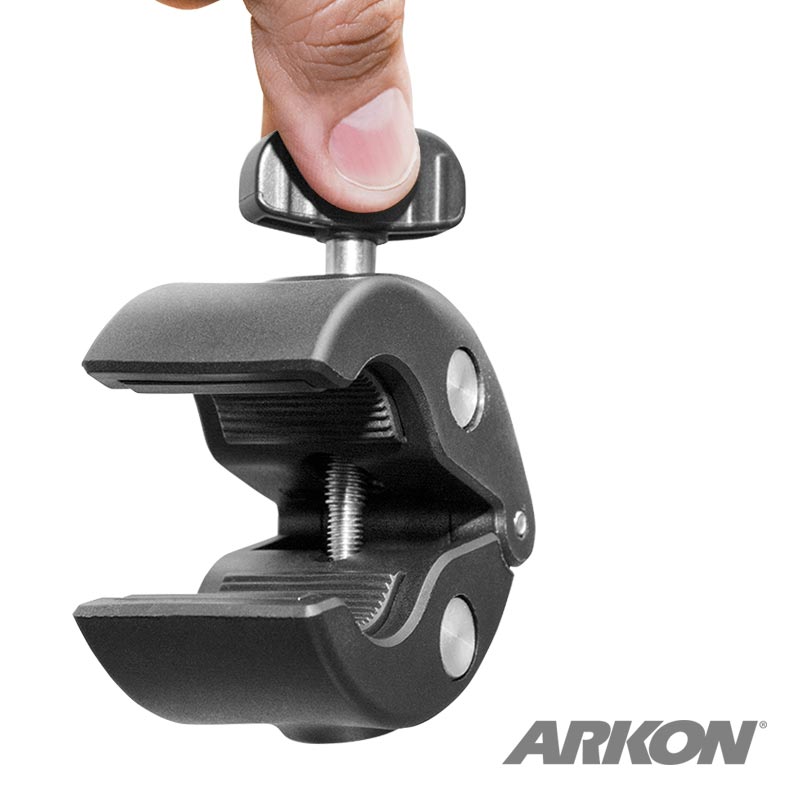 A hand adjusts the Clamp Post Mount -17mm Compatible, a black, heavy-duty clamp with a screw mechanism, shown against a white background. The Arkon logo is visible in the lower right corner.
