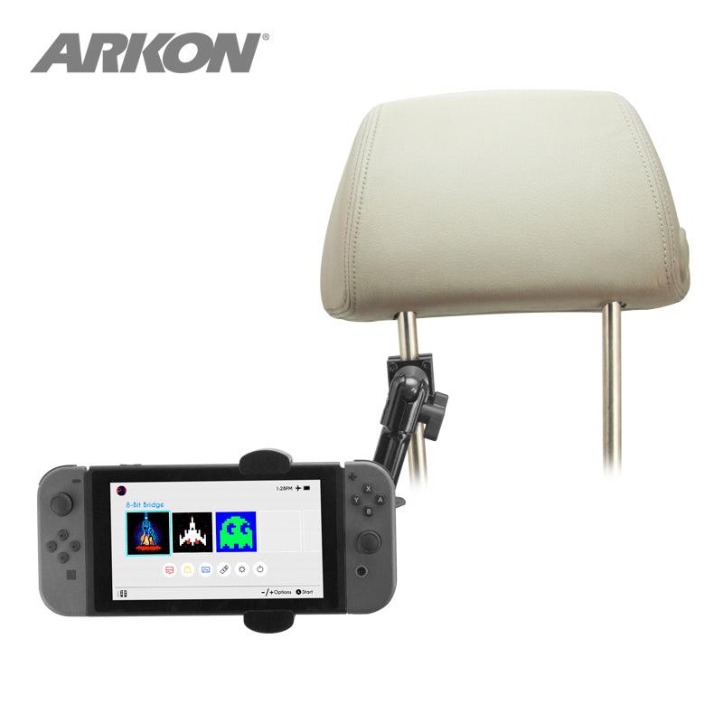 The Heavy-Duty Multi-Angle Headrest Mount in black securely holds a Nintendo Switch (home screen visible) as a rear seat entertainment solution, with both the car headrest and device contrasting against a white background.