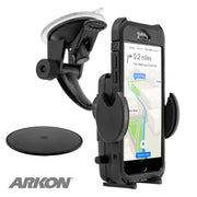 A black Mega Grip™ Phone Holder with Windshield and Dash Car Mount secures a smartphone displaying GPS; it features a suction cup, adjustable holder, circular adhesive pad, and the Arkon logo in the corner.