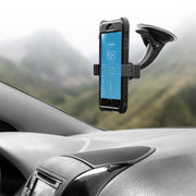 A smartphone in a black case is secured in a Mobile Grip 2 Holder with Suction Mount on the car dashboard, displaying a weather app, with the car interior and blurred mountains visible in the background.