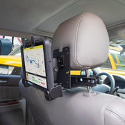 The LockVise™ Locking Car Headrest Tablet Mount secures a tablet to a car seat’s headrest posts, perfect for Uber drivers needing hands-free navigation, with the road visible through the rear window.