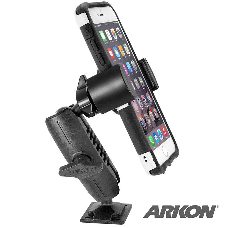 A smartphone rests securely in a black RoadVise® Phone Holder with Drill Base and Adjustable Arm, angled for display. The screen shows app icons, and the Arkon logo is visible in the bottom right corner.