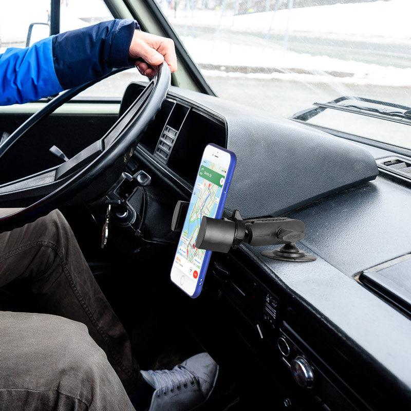 A driver uses a RoadVise® Phone Holder with Adhesive Car or Truck Mount to secure their smartphone as a GPS while gripping the steering wheel and getting ready to drive.