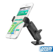 A smartphone displaying a GPS map is held in a black RoadVise® Ultra Metal 4-Hole AMPS Drill-Base Phone or Tablet Mount, attached to a flat surface. The Arkon Mounts logo appears in the bottom right corner.