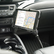 A smartphone in a LockVise™ Metal Locking Seat Rail Tablet Mount with 18 Aluminum Gooseneck and 3.75 shaft shows a navigation map. The heavy-duty mount is attached near the center console beside cup holders, with dashboard controls visible.