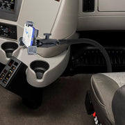 A smartphone secured on the LockVise™ Locking Seat Rail or Floor Phone Mount by the center console, displaying navigation near cup holders and control buttons.