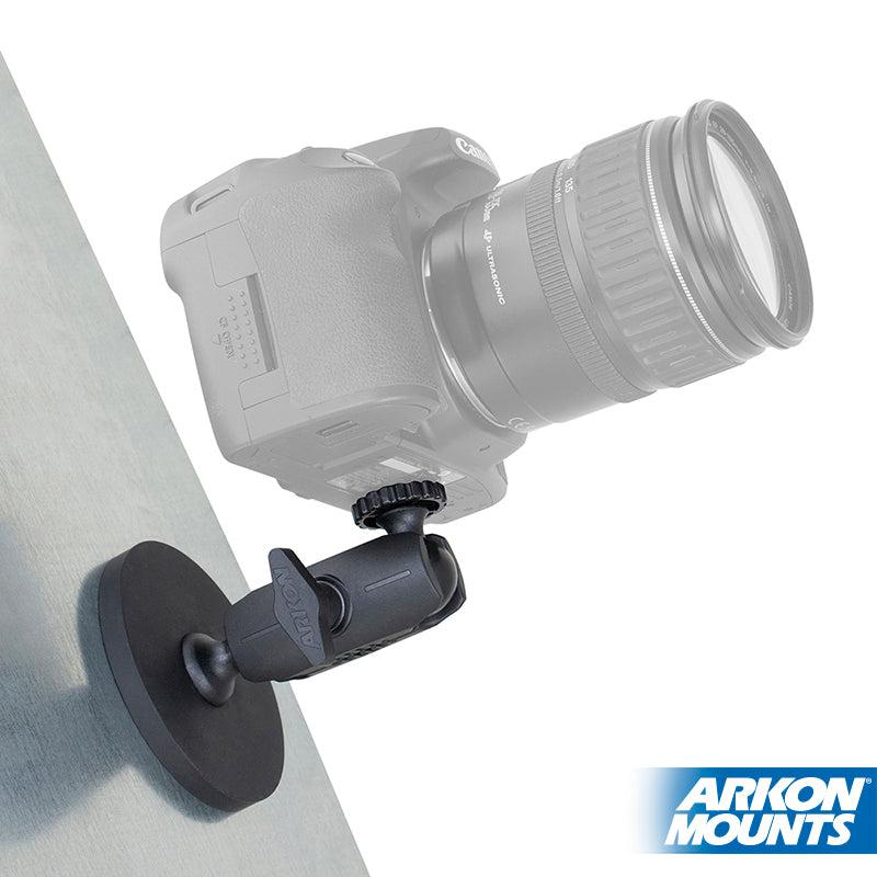 A DSLR camera is mounted on the Robust Magnetic Mount for Cameras and Video Cameras with a sturdy 1/4-20 pattern, attached to a flat surface. The Arkon Mounts logo is visible in the bottom right corner.