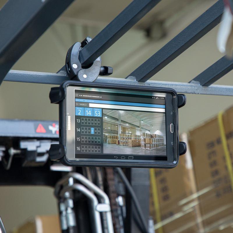 The Slim-Grip® Tablet Holder with Clamp Mount and Security Knob Shaft secures a tablet to a forklift, displaying warehouse inventory data and shelf images for efficient warehouse management or logistics tasks.