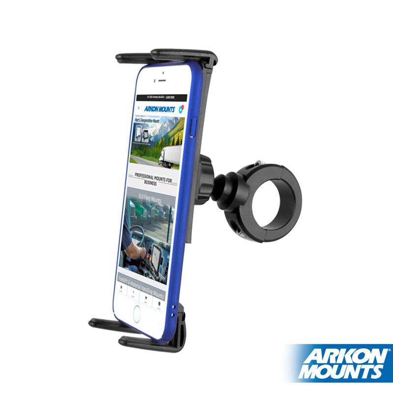 A smartphone is held by the Slim-Grip® Ultra Phone & Tablet Holder with Aluminum Motorcycle Handlebar Mount, displaying a website. The black mount attaches to handlebars, showcasing the Arkon Mounts logo in the bottom right corner.