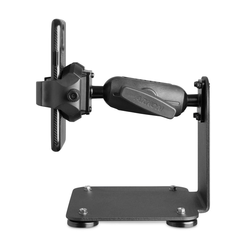Side view of the SteadyMag™ Magnetic Mount System with RoadVise® Ultra Phone Holder in black, mounted on a sturdy metal base with four screws and suction pads, securely holding a smartphone in a clamp-style grip.