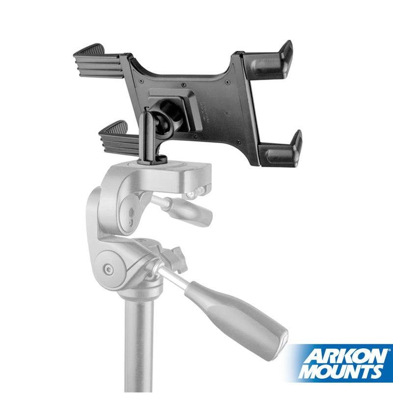 A black Tripod Slim-Grip® Tablet Mount 22mm Ball Compatible is securely attached to a silver tripod as a universal tablet holder. The Arkon Mounts logo appears in the bottom right corner.