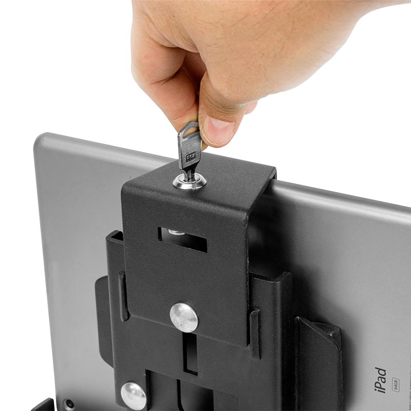 A hand inserts a key into the LockVise™ Metal Locking Tablet Holder, securing the iPad in place with its black metal lock.